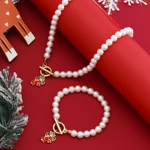 Detailaufnahme von Weihnachts-Perlenkette und Armband-Set mit roten Glockenanhängern