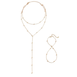 Minimalist gold beaded Y-necklace and matching bracelet set on a white background