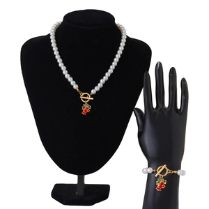 Details von Perlenhalskette und Armband mit goldenem OT-Verschluss und Weihnachtsglocke