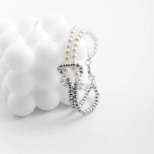 Detalle de un set de pulseras de cuentas con perlas blancas y cuentas de plata con mosquetón