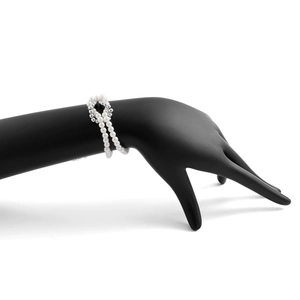 Primer plano de una pulsera multicapa con perlas y cuentas plateadas en un modelo