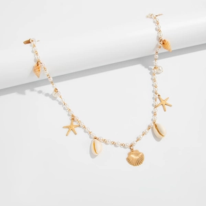 Close-up of golden sea star and seashell charms on a pearl body chain belt