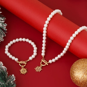 Detail von Perlenkette und Armband mit goldenen Schneeflocken und OT-Verschluss