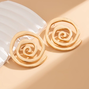 Detailansicht kunstvoller goldener Spiralohrringe auf minimalistischem Display