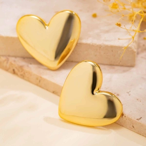 Detailed close-up of golden liquid heart earrings with high polished mirror finish