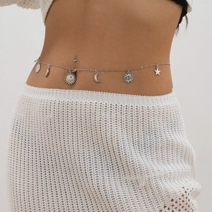 Silver waist chain with sun and moon charms worn over white crochet dress