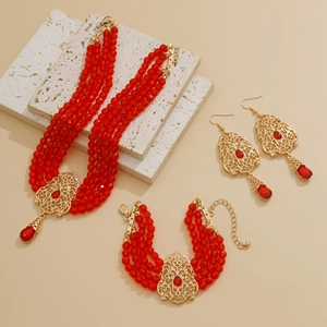 Detalle del conjunto de collar de cristal rojo con acentos dorados y borlas de gota de agua
