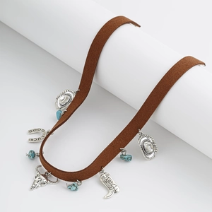 Détail du collier de cowboy avec tête de taureau argentée, pendentifs chapeau et turquoise