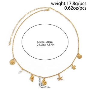 Detailed view of a gold chain belt with seashell, starfish, and turtle charms on white