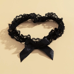 Détail d'une jarretière gothique en dentelle noire avec un grand nœud en satin élégant