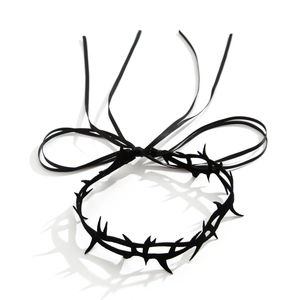 Detailansicht eines gothischen schwarzen Dornen-Chokers mit langen Bändern auf weißem Grund