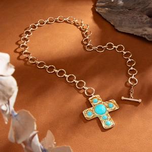 Detail van vintage gouden ketting met een turkoois kruishanger en klassieke OT-schakelsluiting