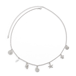 Detail of silver chain body jewelry featuring starfish, shell, and sea turtle charms