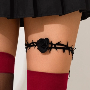 Détail d'un anneau de cuisse gothique avec rose noire et dentelle de ronces