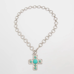 Detail van zilveren ketting met turquoise kruishanger en vintage OT-schakelsluiting voor