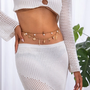 Detailed view of layered gold body chain with starfish, shell, and pearl charms