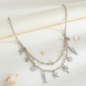 Detailed close-up of double-layer silver body chain with seashells and pearls