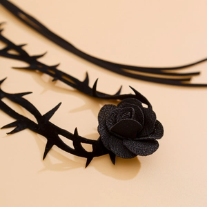 Vue macro du ras de cou gothique en velours noir avec détails de roses et d'épines