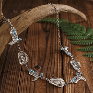 Punk bodychain in westernstijl met zilveren cowboylaarzen, hoeden en turquoise kralen
