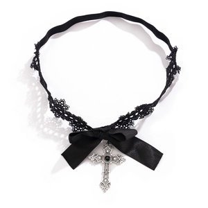 Détail de jarretière en dentelle noire gothique avec nœud et pendentif croix vintage