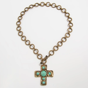 Detail van vintage punk metalen ketting met kruis hanger en groene turquoise stenen