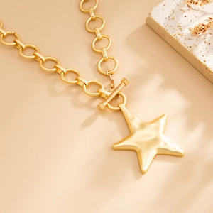 Detailopname van gouden sterhanger en grove schakelketting met een klassieke OT-sluiting