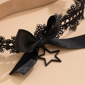 Nahaufnahme eines schwarzen Spitzenhalsbands mit Satin Schleife und Stern Anhänger