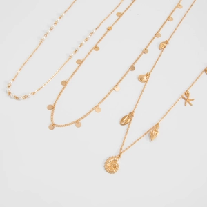 Detailed close-up of gold chain belts featuring starfish, sea shells and faux pearls