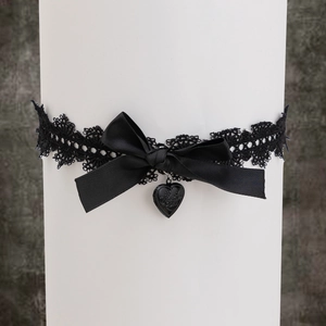 Détail macro d'une chaîne de cuisse en dentelle noire gothique avec nœud en satin
