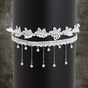 Détail du ras de cou en dentelle blanche avec chaînes argentées et perles fantaisie