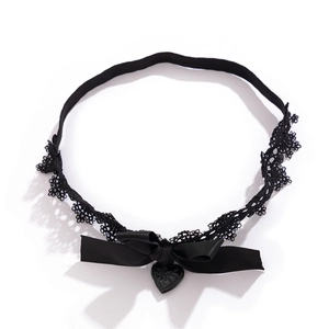 Détail de jarretière en dentelle noire avec nœud et pendentif cœur gravé Love You