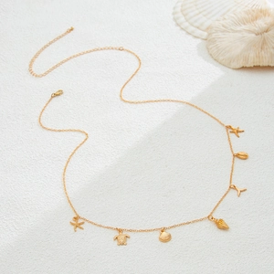 Detail of gold beach chain featuring sea star, turtle, shell, and whale tail charms