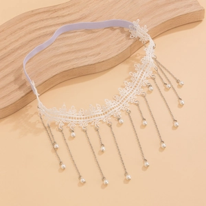 Détail d'un anneau de cuisse en dentelle blanche avec chaînes argentées et perles