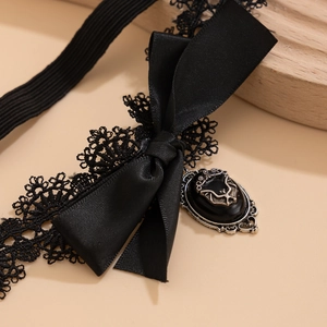 Détail macro d'un anneau de cuisse en dentelle gothique avec nœud satin et pendentif chauve-souris