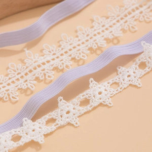 Détail du ruban en dentelle florale blanche et bandes élastiques pour jarretière DIY