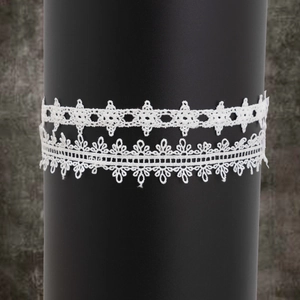 Détail montrant les motifs de dentelle blanche complexe et les textures florales