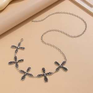 Close-up of gothic silver body chain featuring cross charms with small skull centers