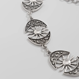 Gothic silver body chain featuring vintage sun and moon charms for a celestial look