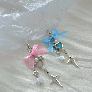 Close-up of Y2K style strawberry phone charms with satin bows and heart beads