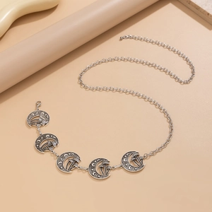 Detail of vintage silver moon pendants with mushroom and star patterns on metal chain