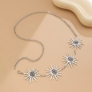 Detail of silver sun charms and star engravings on a bohemian gothic style body chain