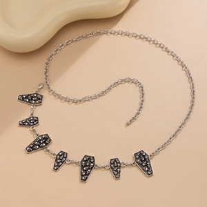 Detailed view of silver gothic waist chain with ornate coffin-shaped skull pendants