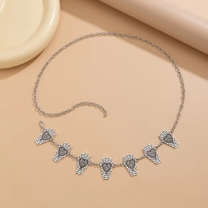 Detail view of silver gothic body chain with coffin charms and spider web patterns