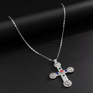Vue macro détaillée du pendentif croix argenté avec pierres précieuses et relief vintage