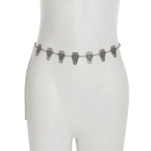 Close-up of gothic silver coffin charms with spiderweb details on a metal body chain