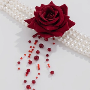Detail of red velvet rose choker with multi-layer faux pearls and red beaded tassels