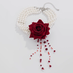 Detail of multi-layer pearl choker with red velvet rose and blood-red beaded tassels