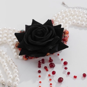Detail of gothic pearl choker with black velvet rose and red crystal fringe drops