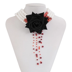 Detail of multi-layer beaded necklace with black rose flower and red pearl tassels