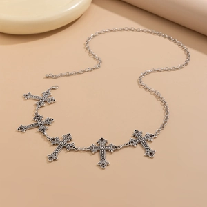 Detailed macro view of vintage silver metal cross pendants on a gothic body chain accessory